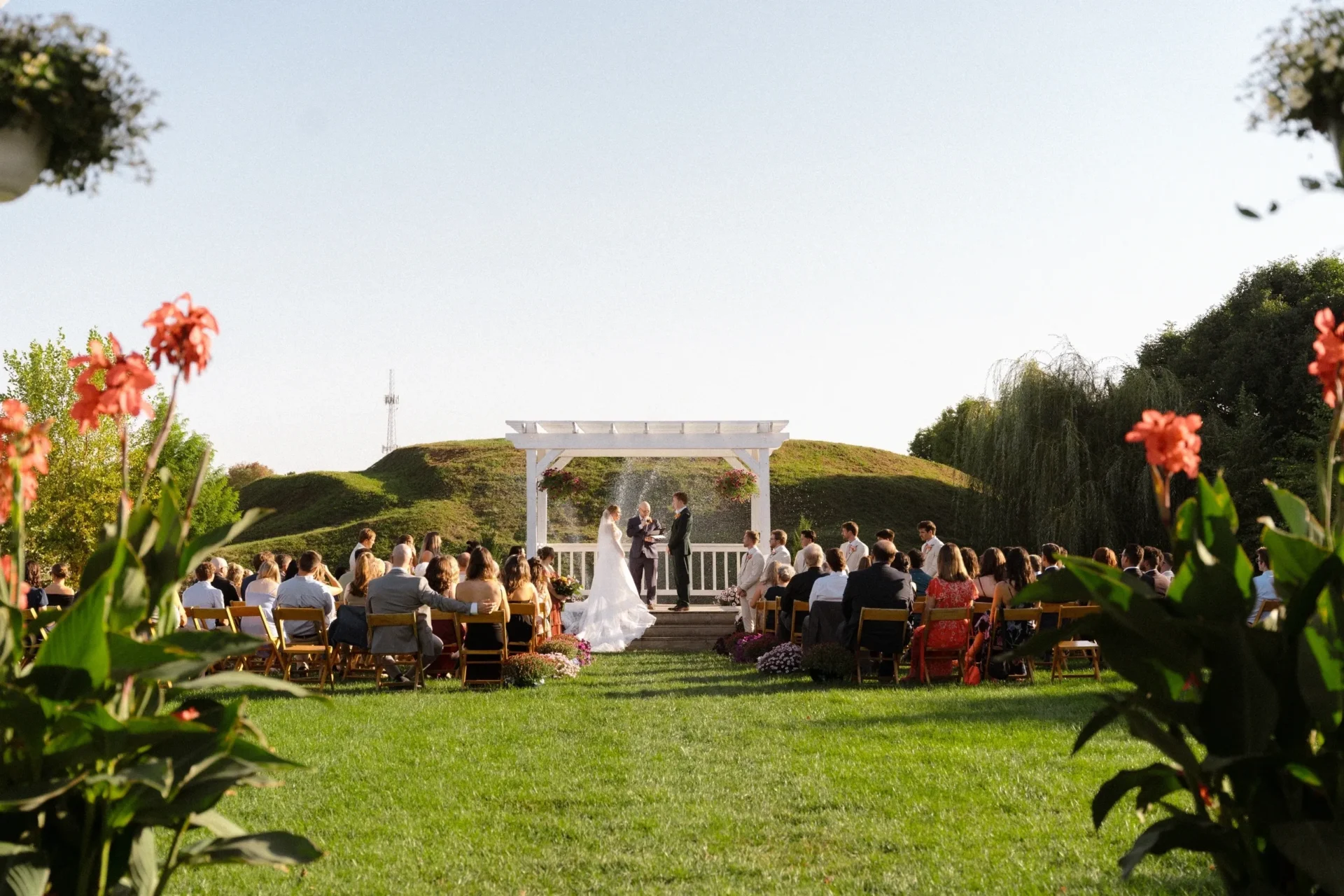 Outdoor wedding ceremony under white pergola