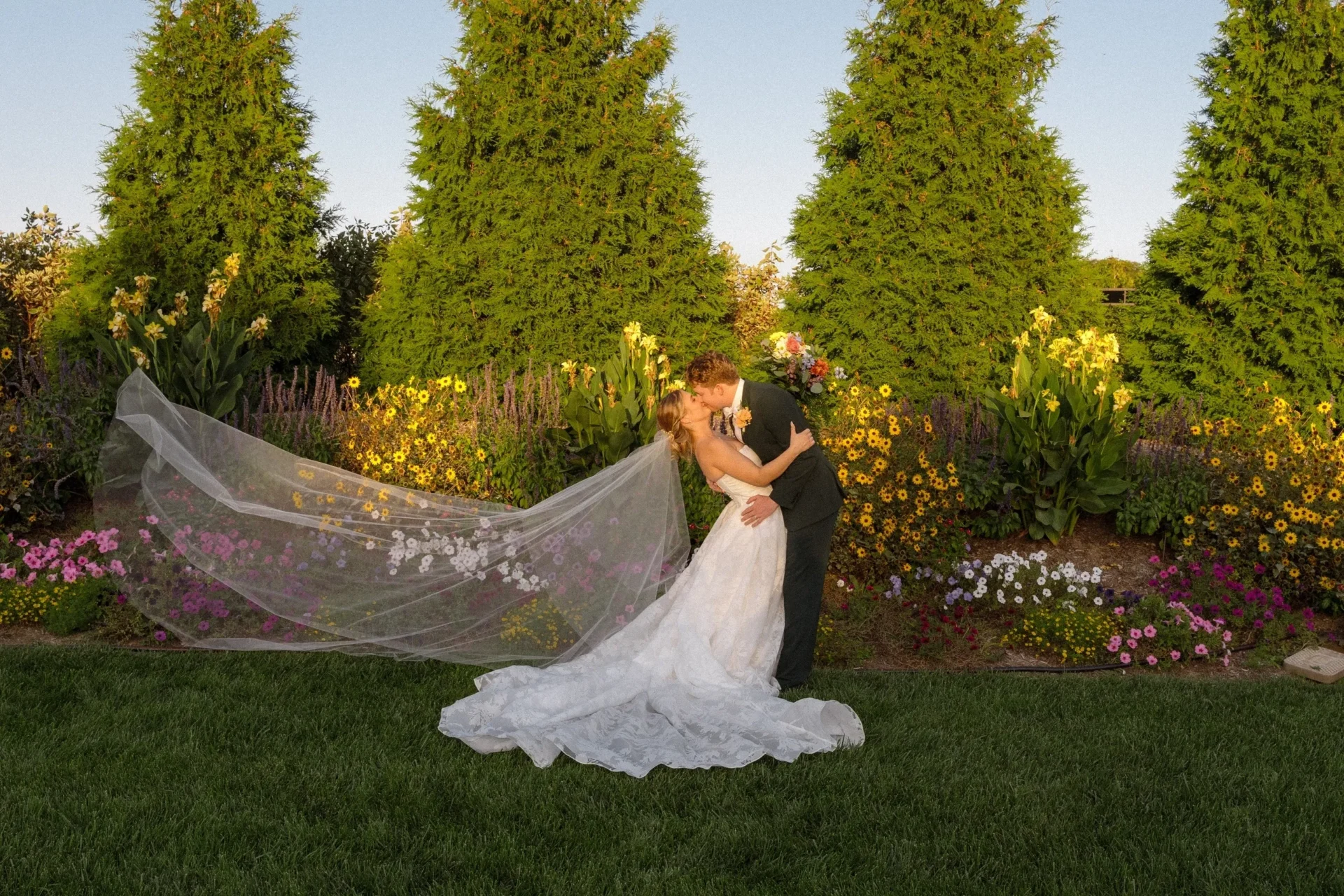 Bride and groom kissing in garden
