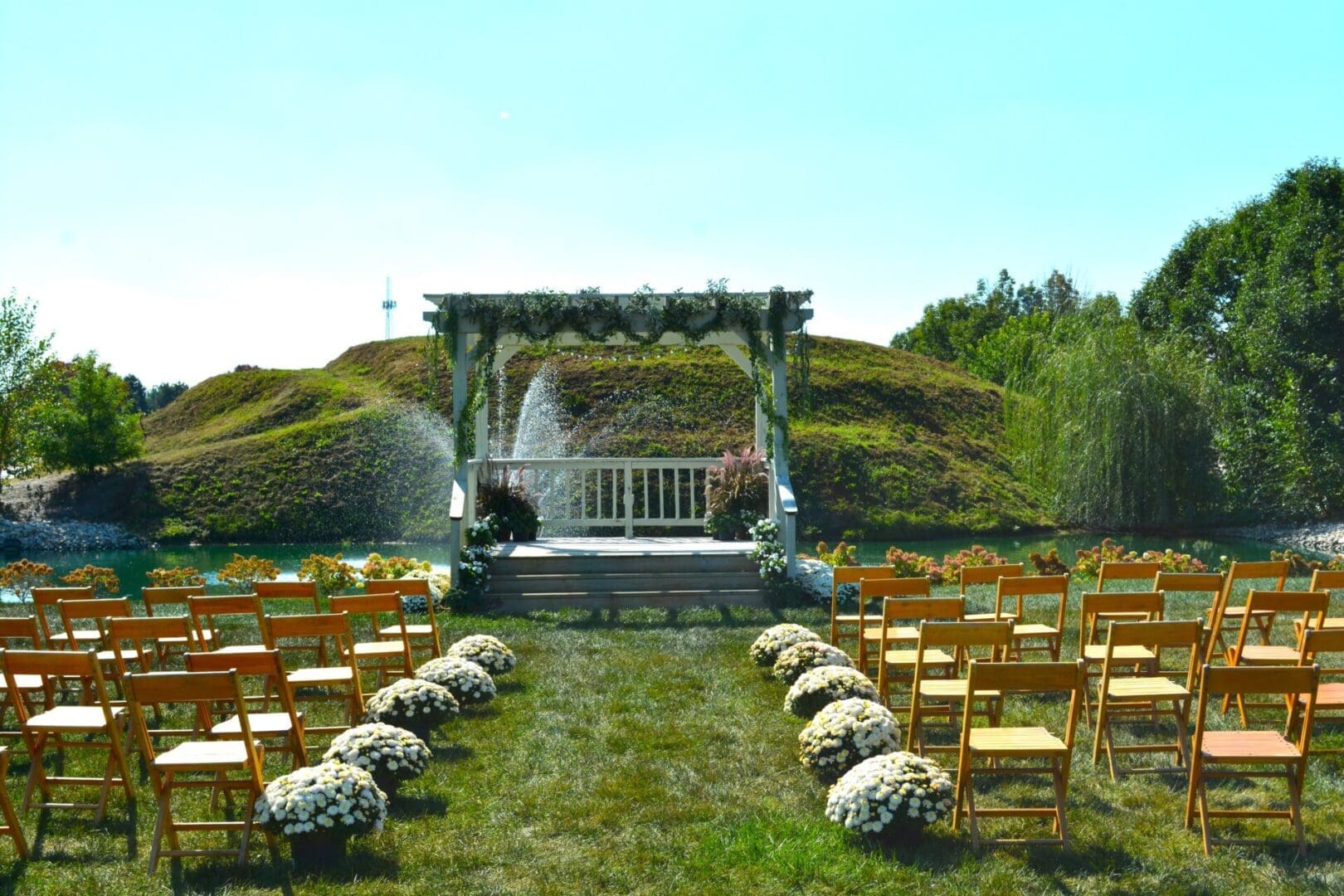 Outdoor wedding aisle with floral arch and fountain