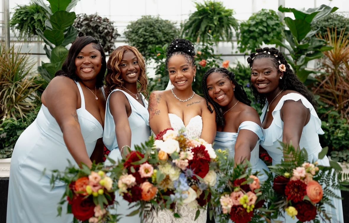 Bride and bridesmaids with bouquets in greenhouse